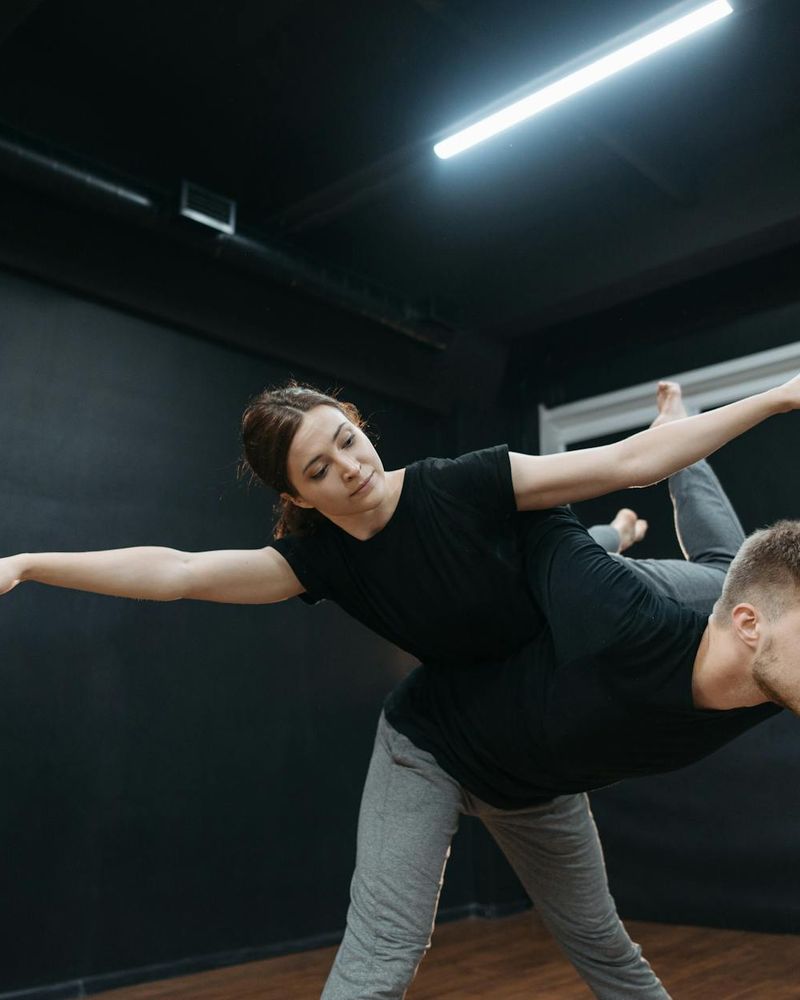 Man performing a slow yoga movement in a minimalist studio.